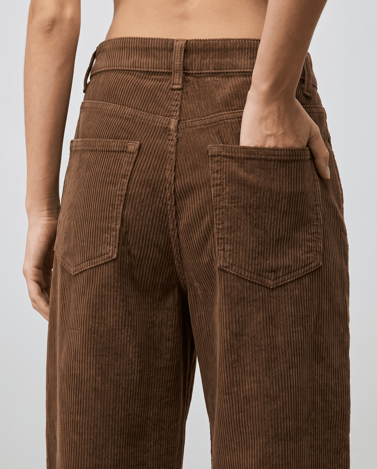 Close-up of stitched back patch pockets and belt loops on chocolate brown corduroy