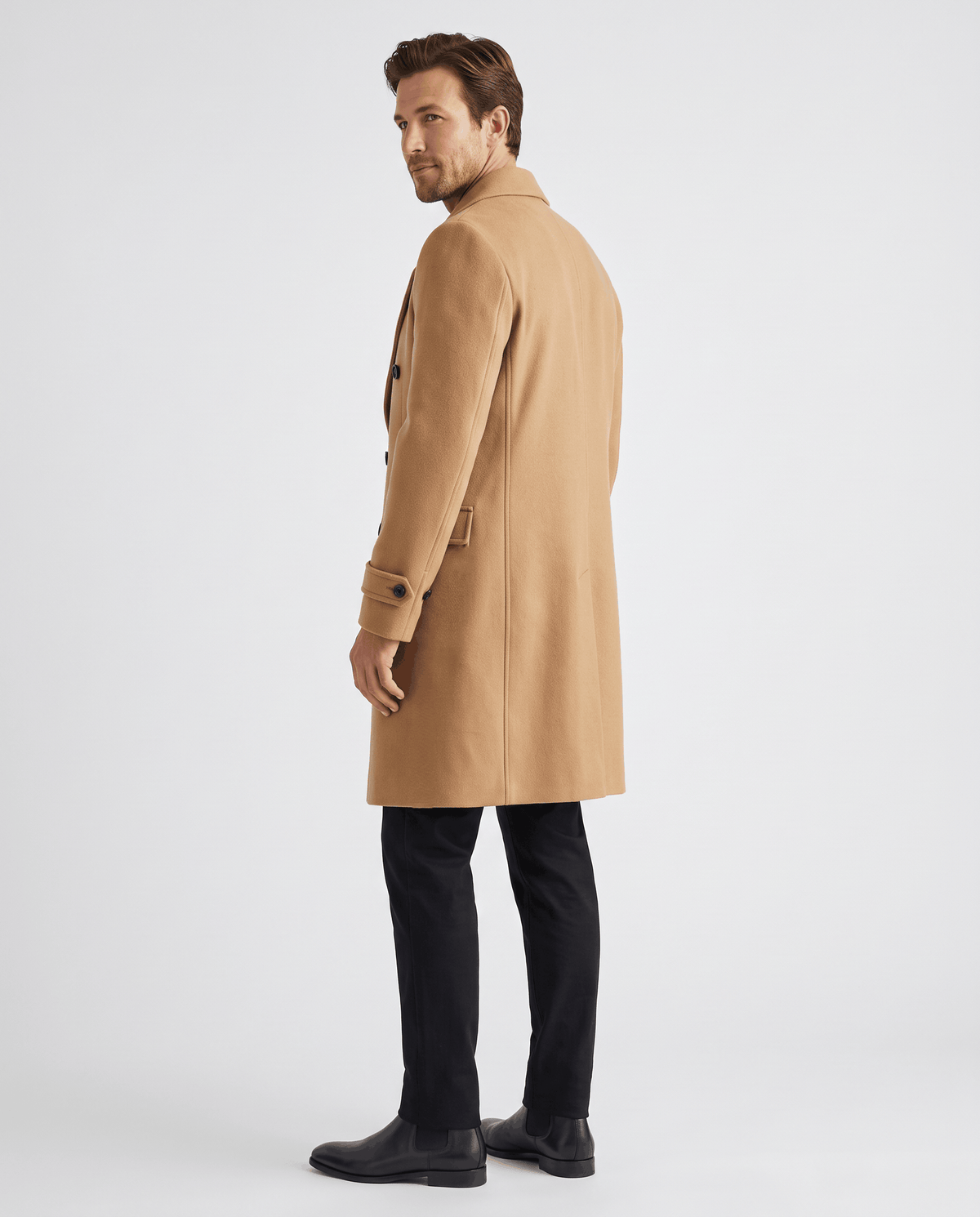 Side view of a beige wool coat showing the long, tailored length