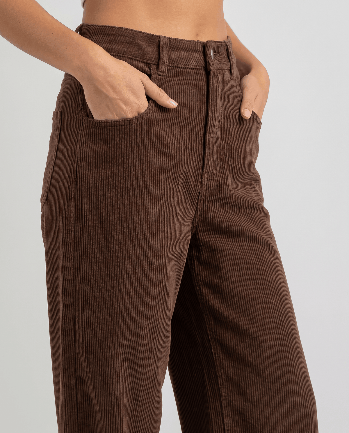 Close-up of brown corduroy at the front with a hand in the scoop pocket