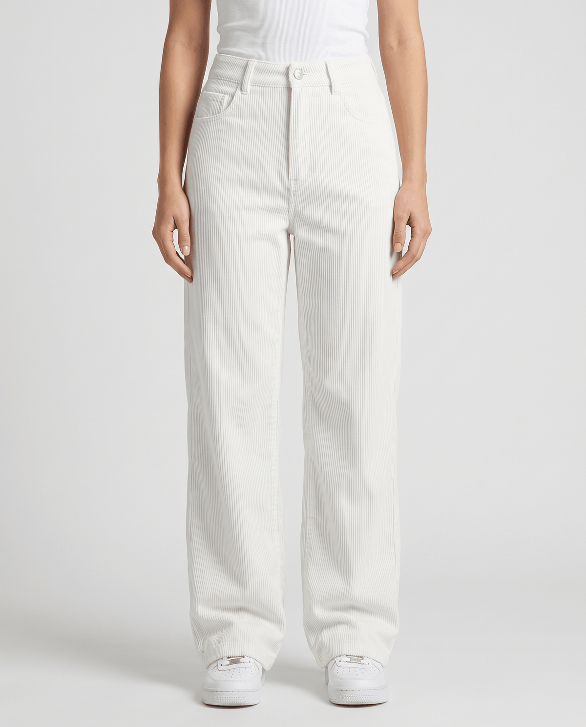 Front view of cream white wide-leg trousers worn with a white tee and sneakers