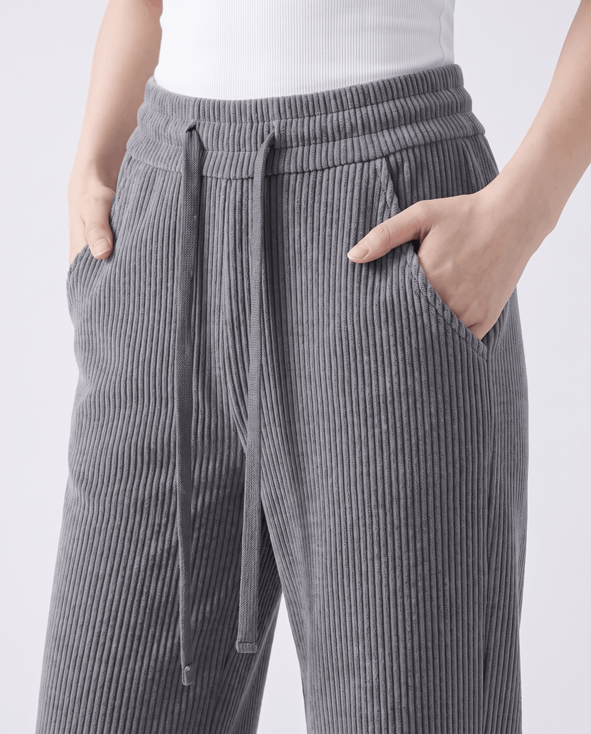 Close-up of the gray drawstring waistband with hands in the slanted side pockets