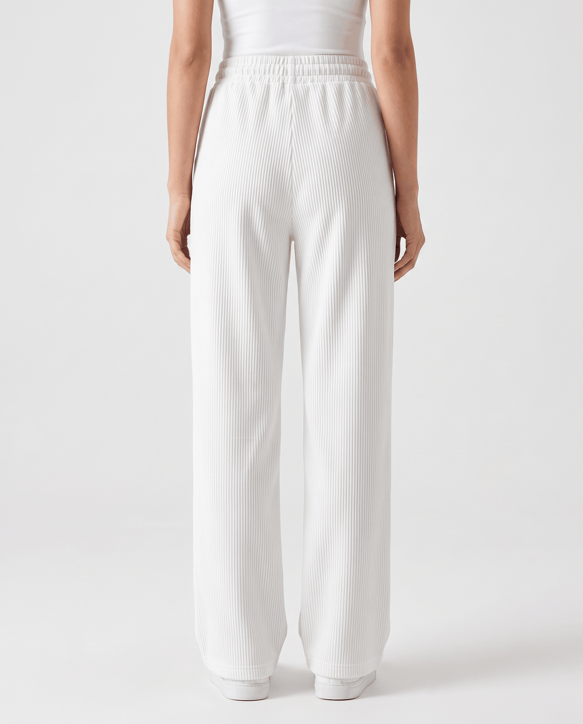 Back view of off-white ribbed pants showing the elastic waistband and full-length leg