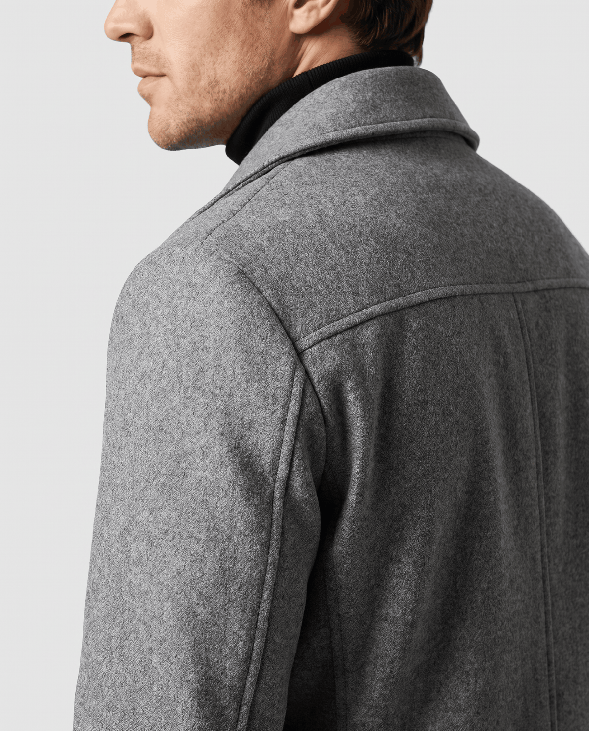 Side view of a gray wool coat showing the sleeve and structured shoulder