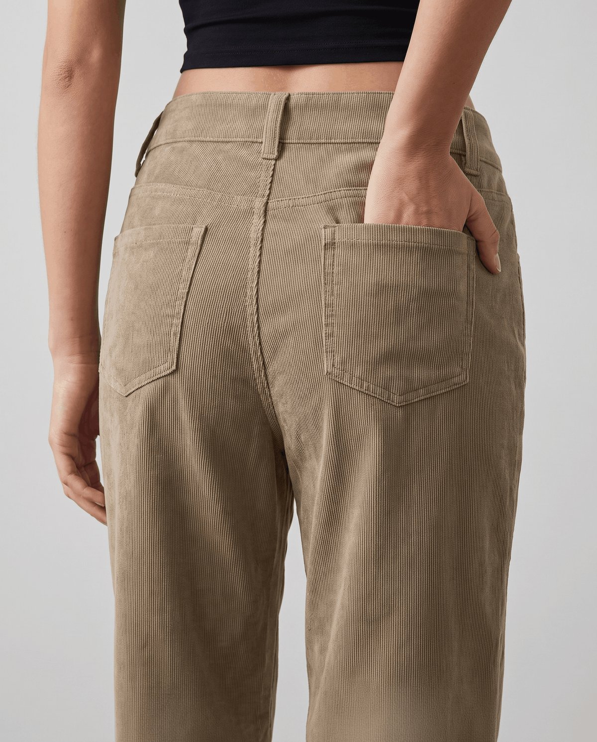Close-up of the back patch pockets and belt loops on soft khaki ribbed fabric