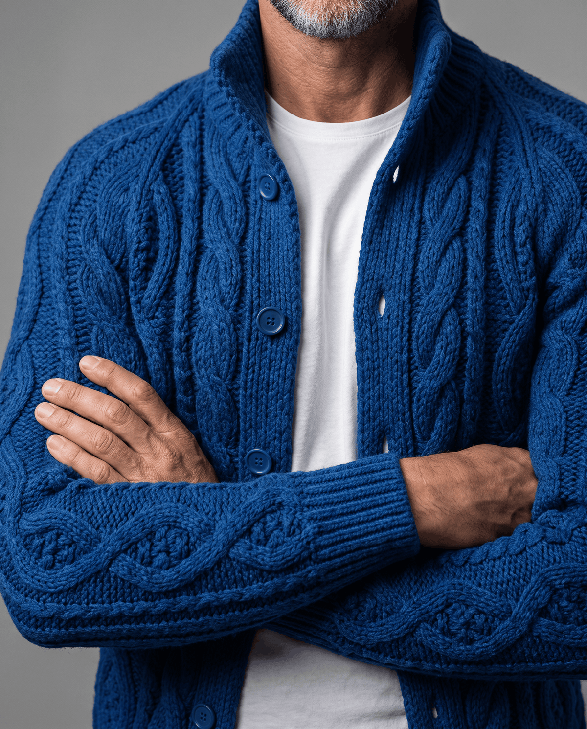 Blue cardigan with arms crossed showing cable-knit texture and button front