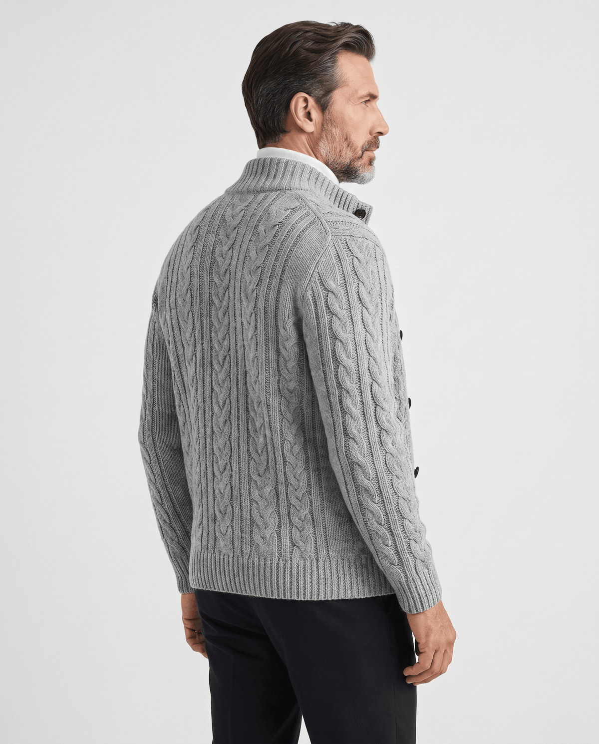 Back view of gray cable knit cardigan worn with dark trousers
