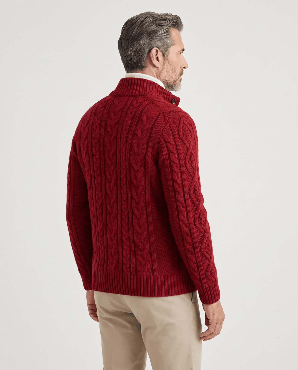 Back view of red cable knit cardigan worn with beige trousers