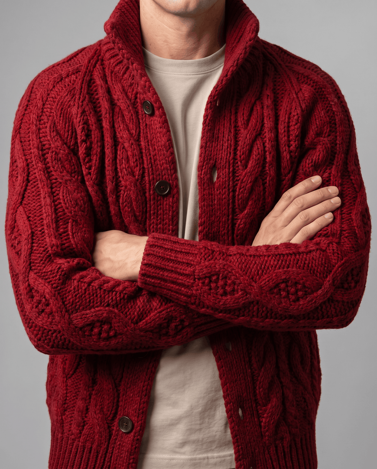 Red cardigan with arms crossed showing cable-knit texture and ribbed cuffs