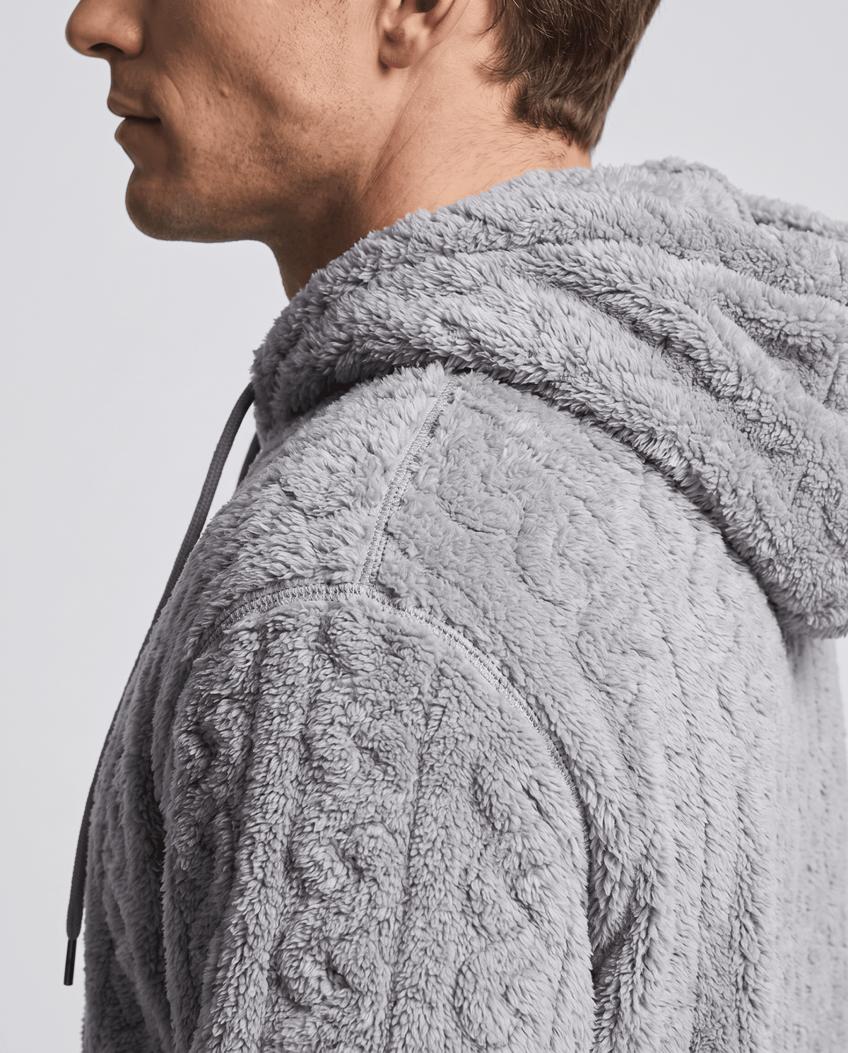 Side close-up of gray hood and drawstring with soft plush cable texture