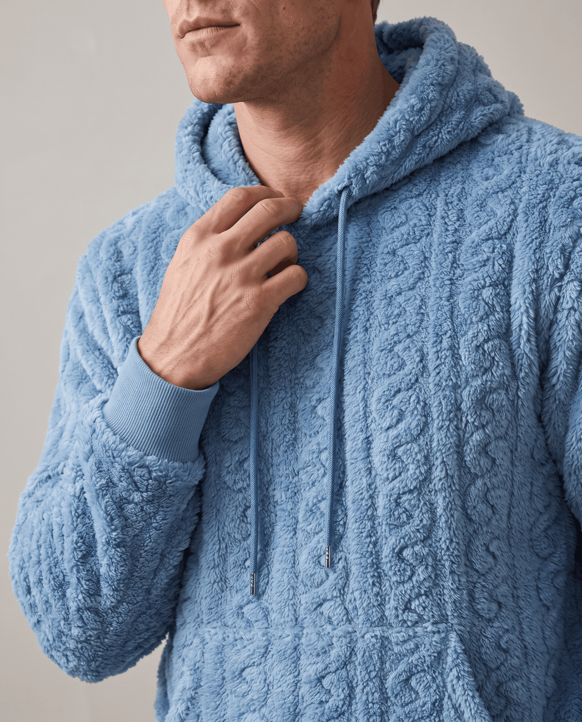Close-up of light blue hoodie collar, drawstring and plush cable pattern