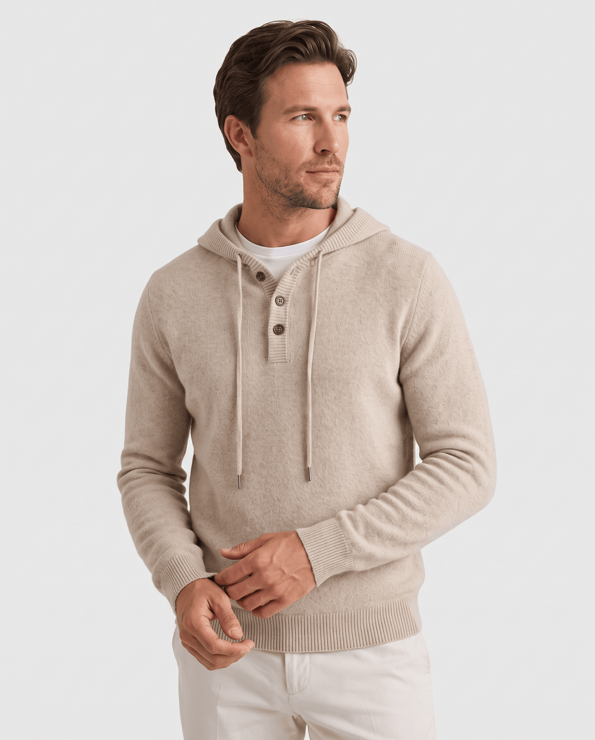Man wearing a beige fine knit pullover hoodie with a three-button placket, front view