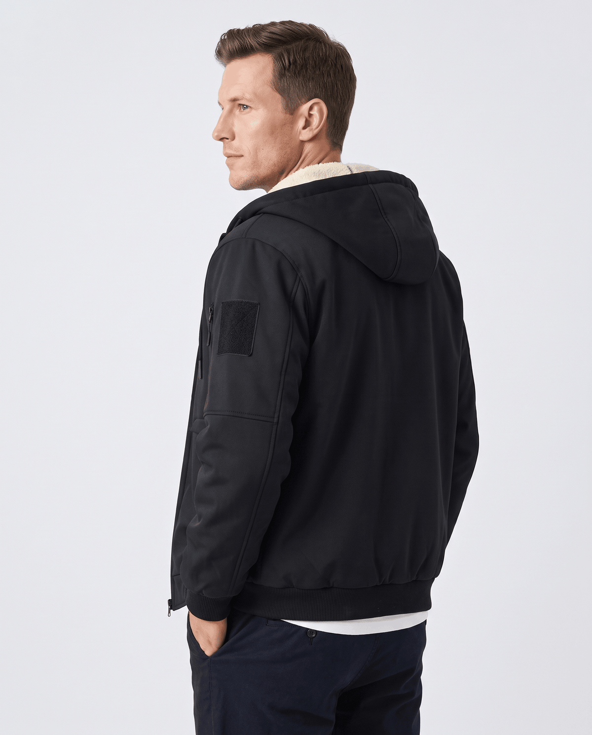 Back of black hooded jacket with fleece lining at the collar and a sleeve patch pocket