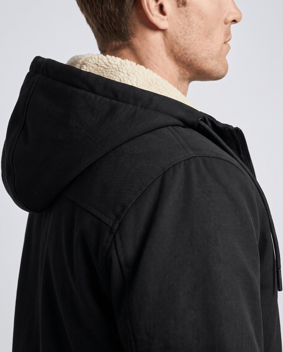 Side close-up of black jacket hood with soft fleece lining at the collar