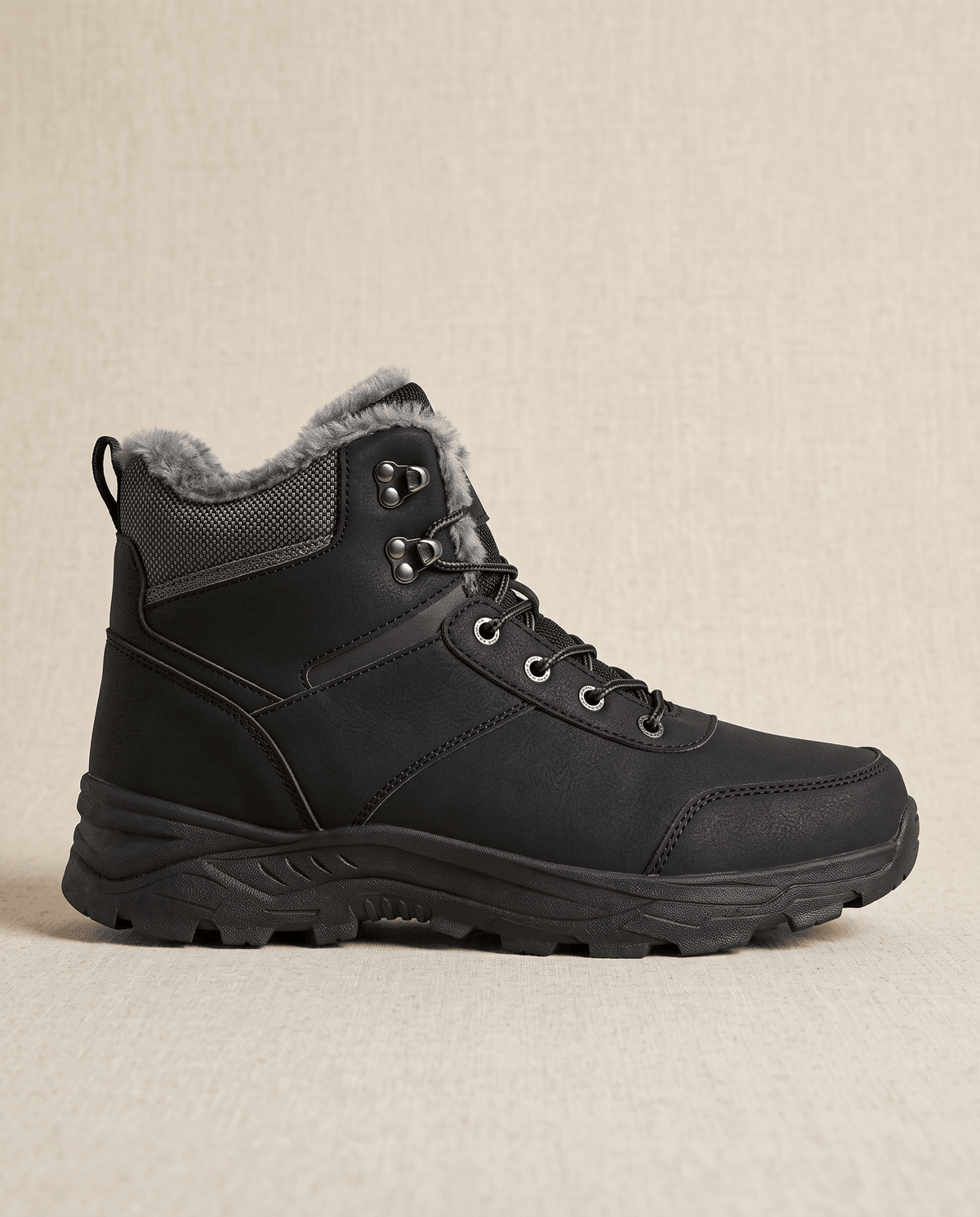 Black winter ankle boot with a padded collar and textured sole on a neutral background.