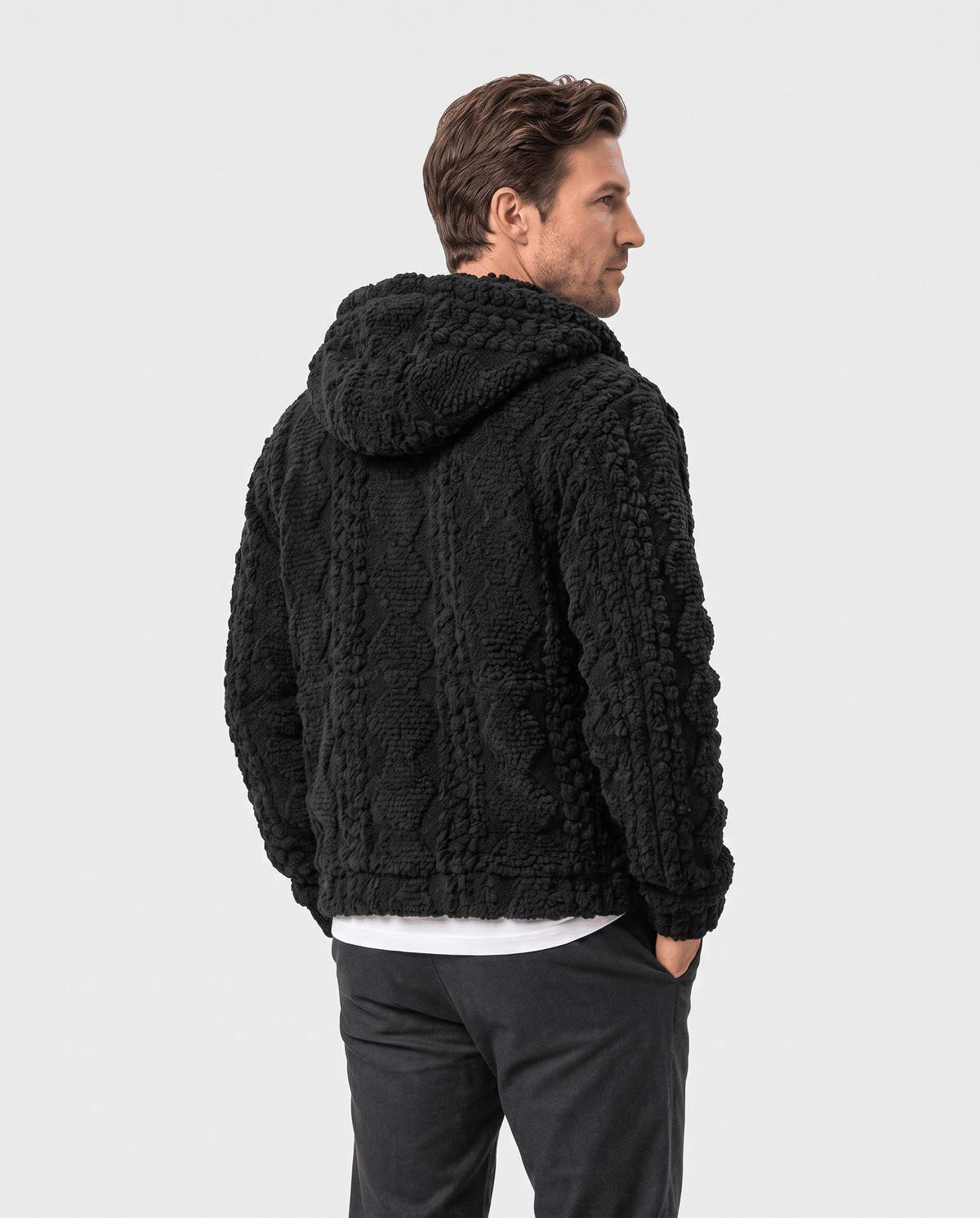 Back of black hooded jacket showing the cable pattern, hood and relaxed fit