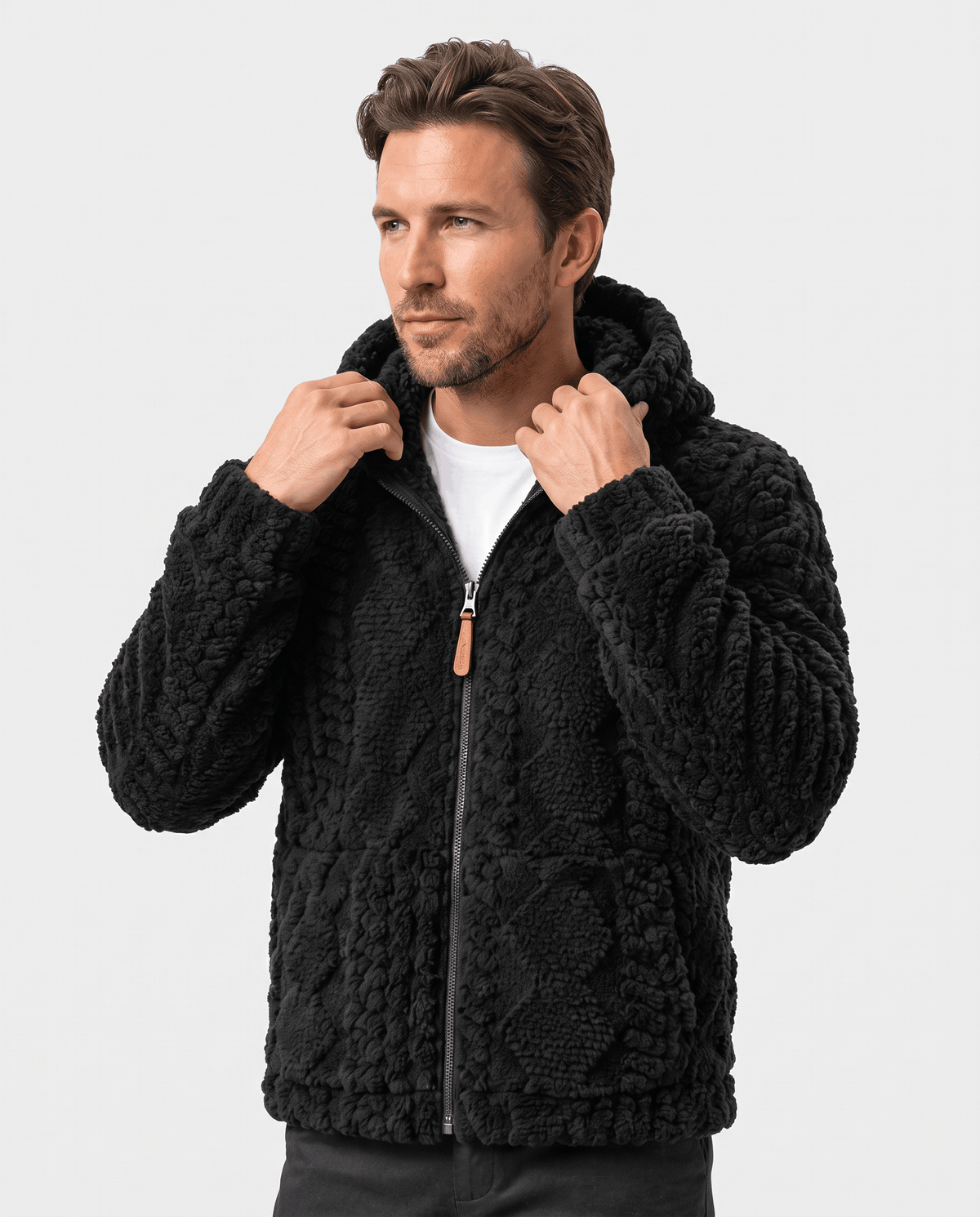 Front view of black hooded jacket with hands holding the collar and zip pull