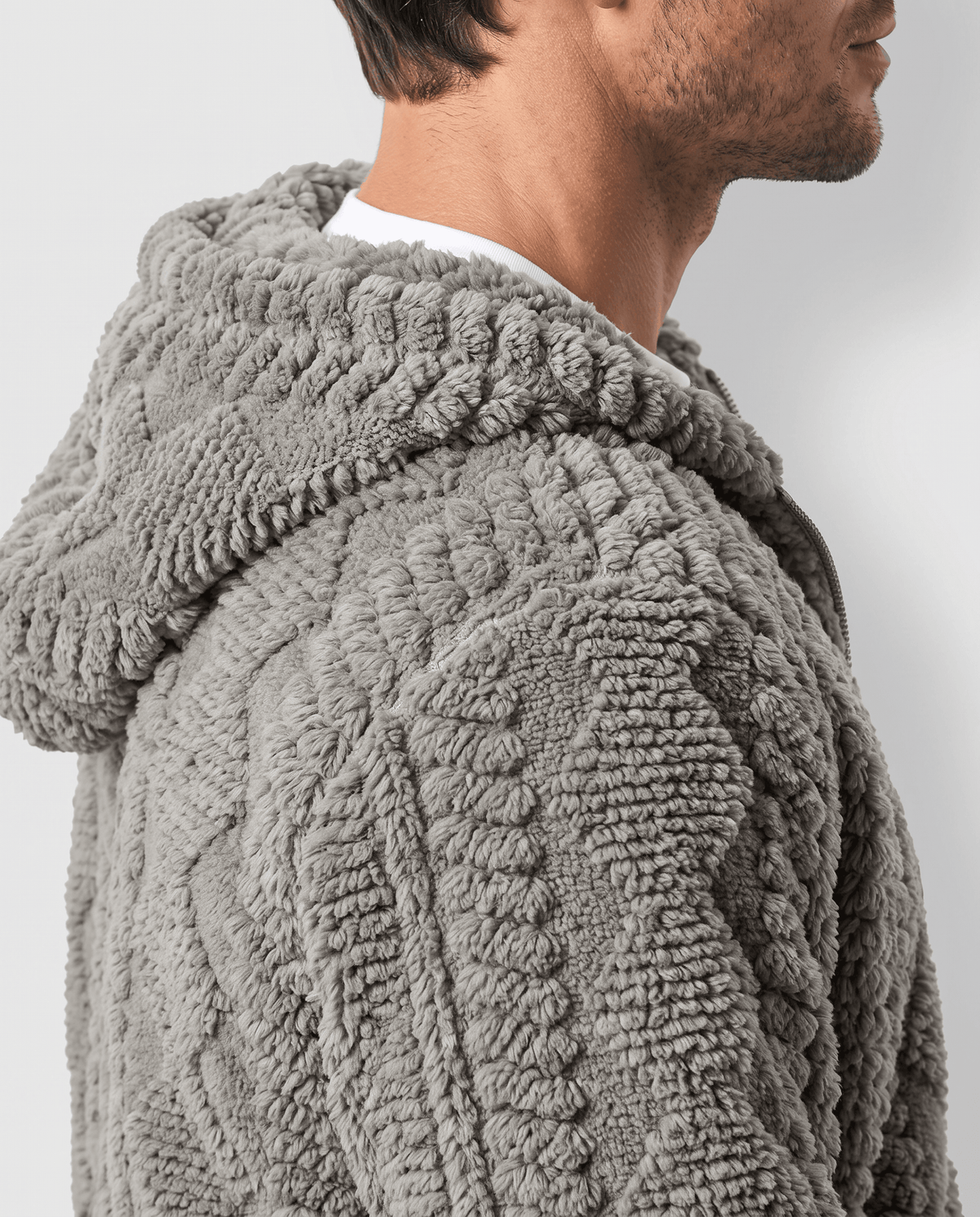 Side view of gray jacket hood and cable-knit shoulder texture up close