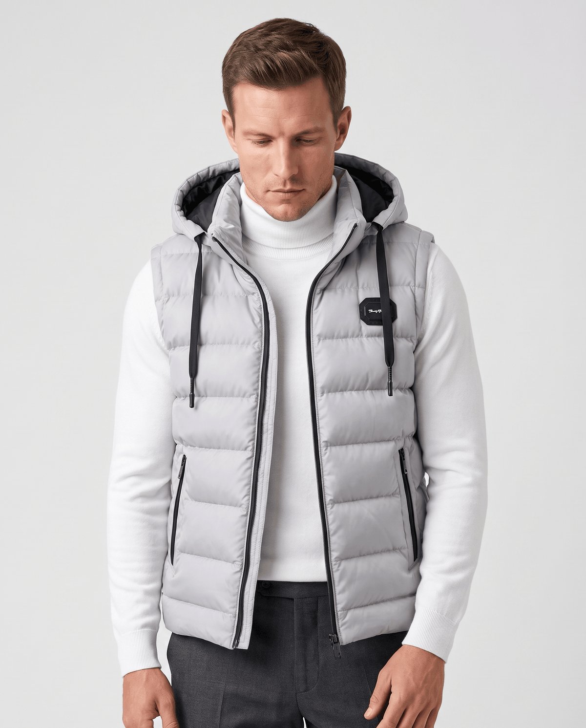 Light gray hooded quilted vest over a white turtleneck, drawstrings hanging at the front