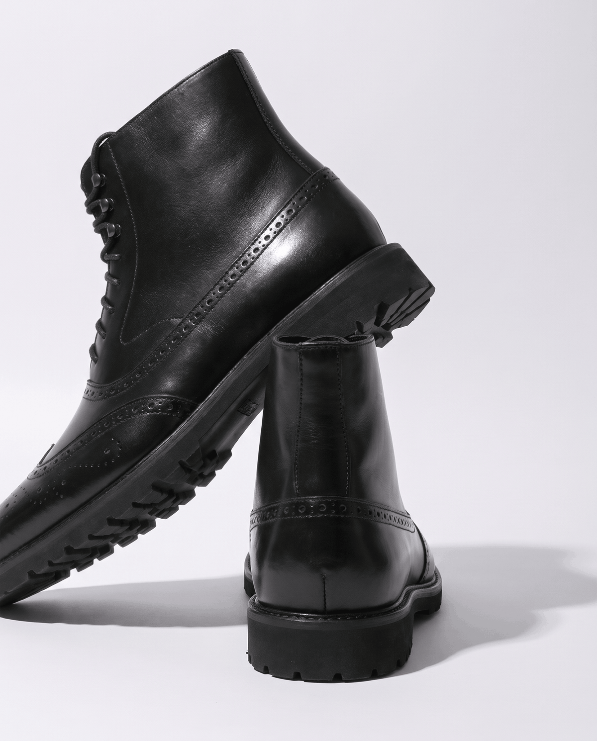 Black leather ankle boot with a second boot behind it, shown from the side