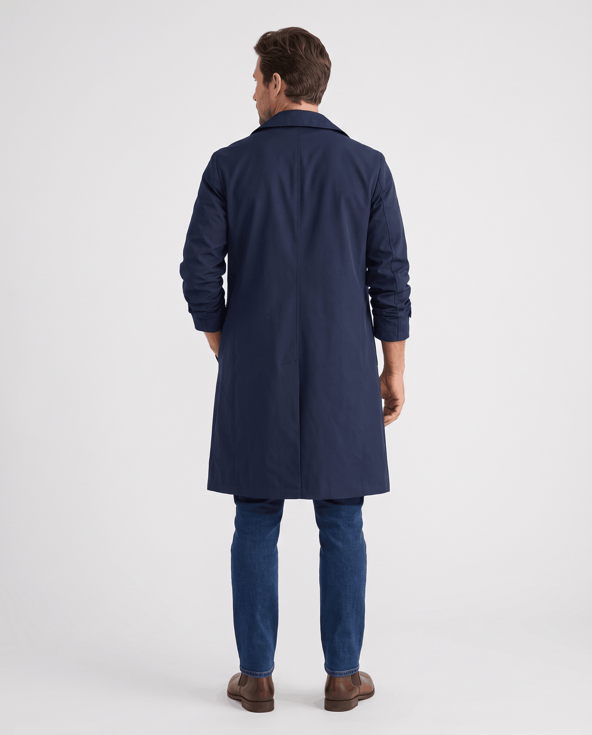 Back of the navy coat showing the clean shoulder line, center vent and long length with jeans