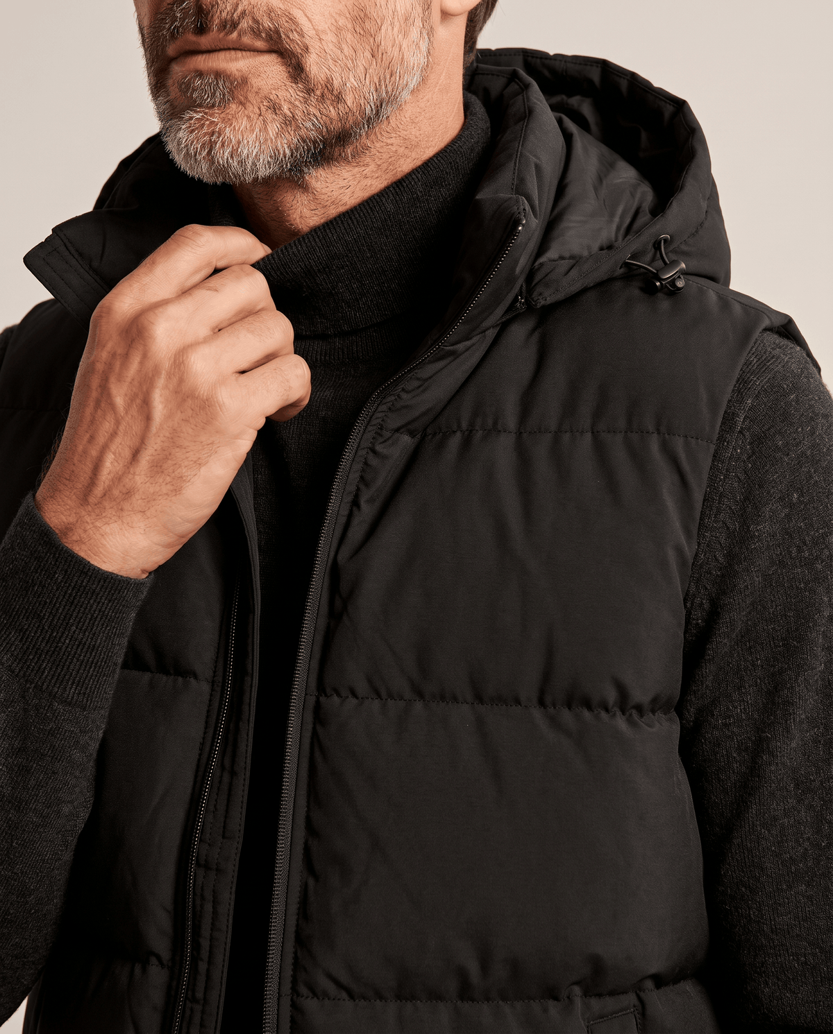 Black padded vest hood and zip shown in close view