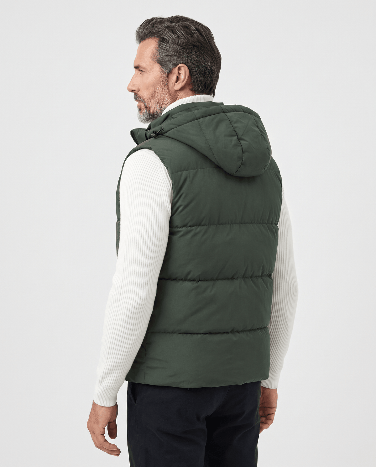 Side view of military green padded hooded vest on a model