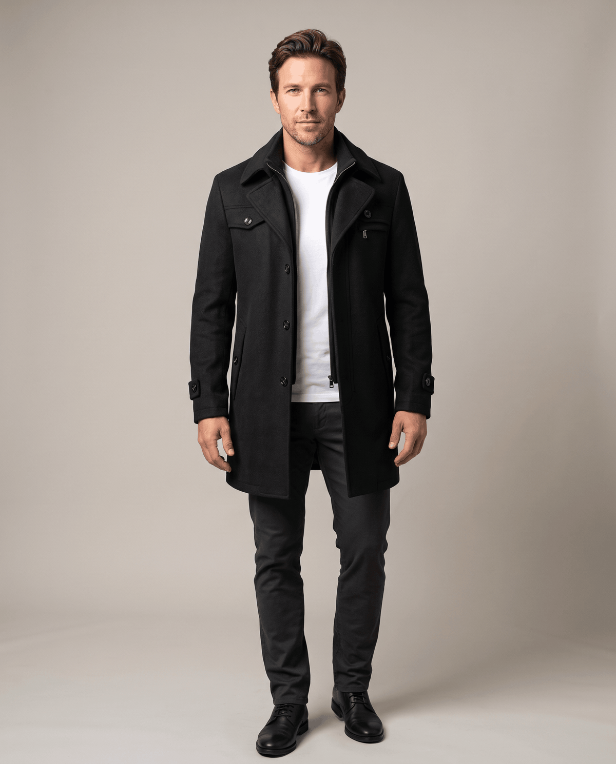 Front view of the black overcoat buttoned over a white tee and dark trousers