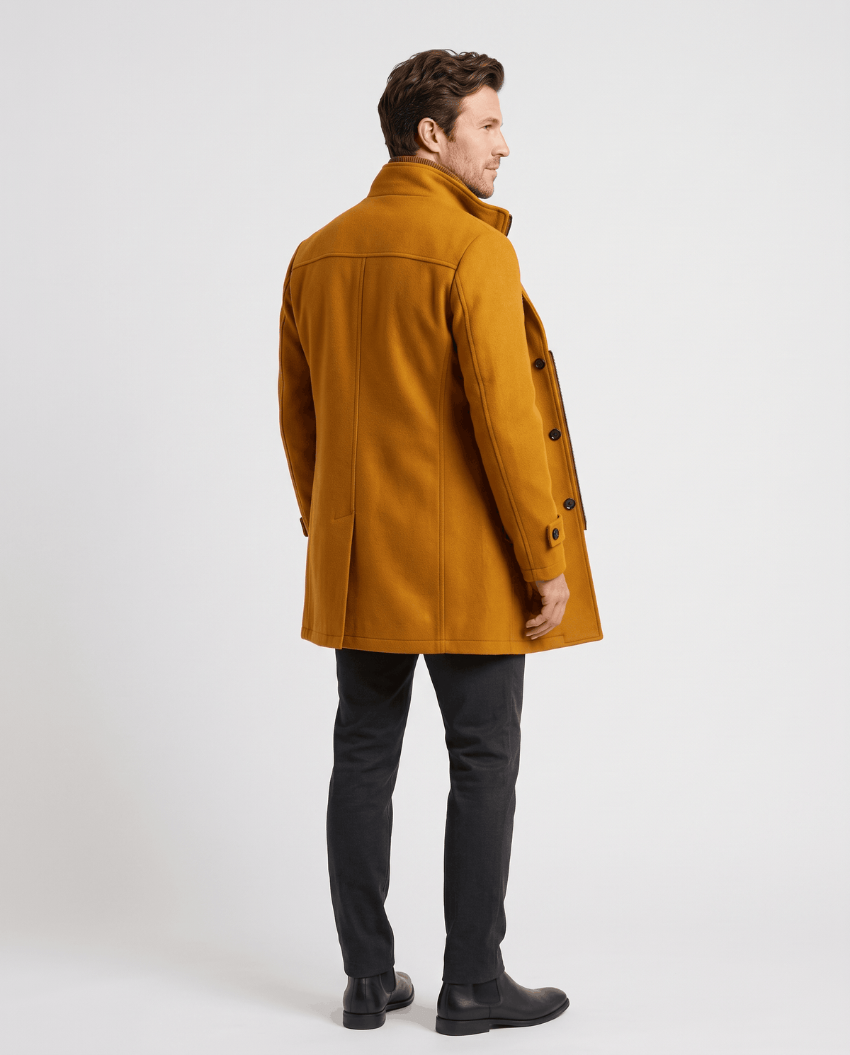 Side view of the brown overcoat in a walking pose, worn with dark trousers