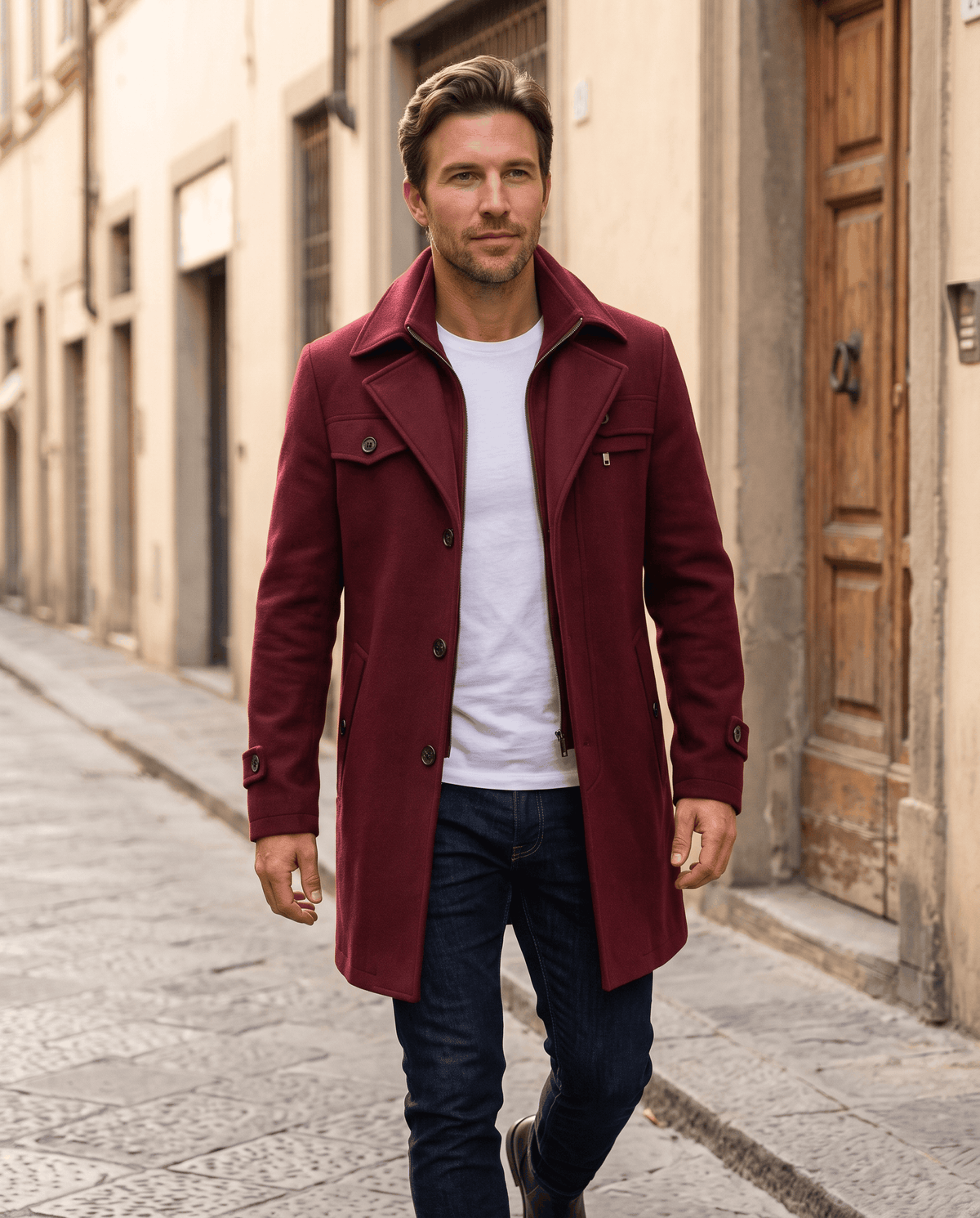 Man in the burgundy overcoat standing on a sunlit street in an old town