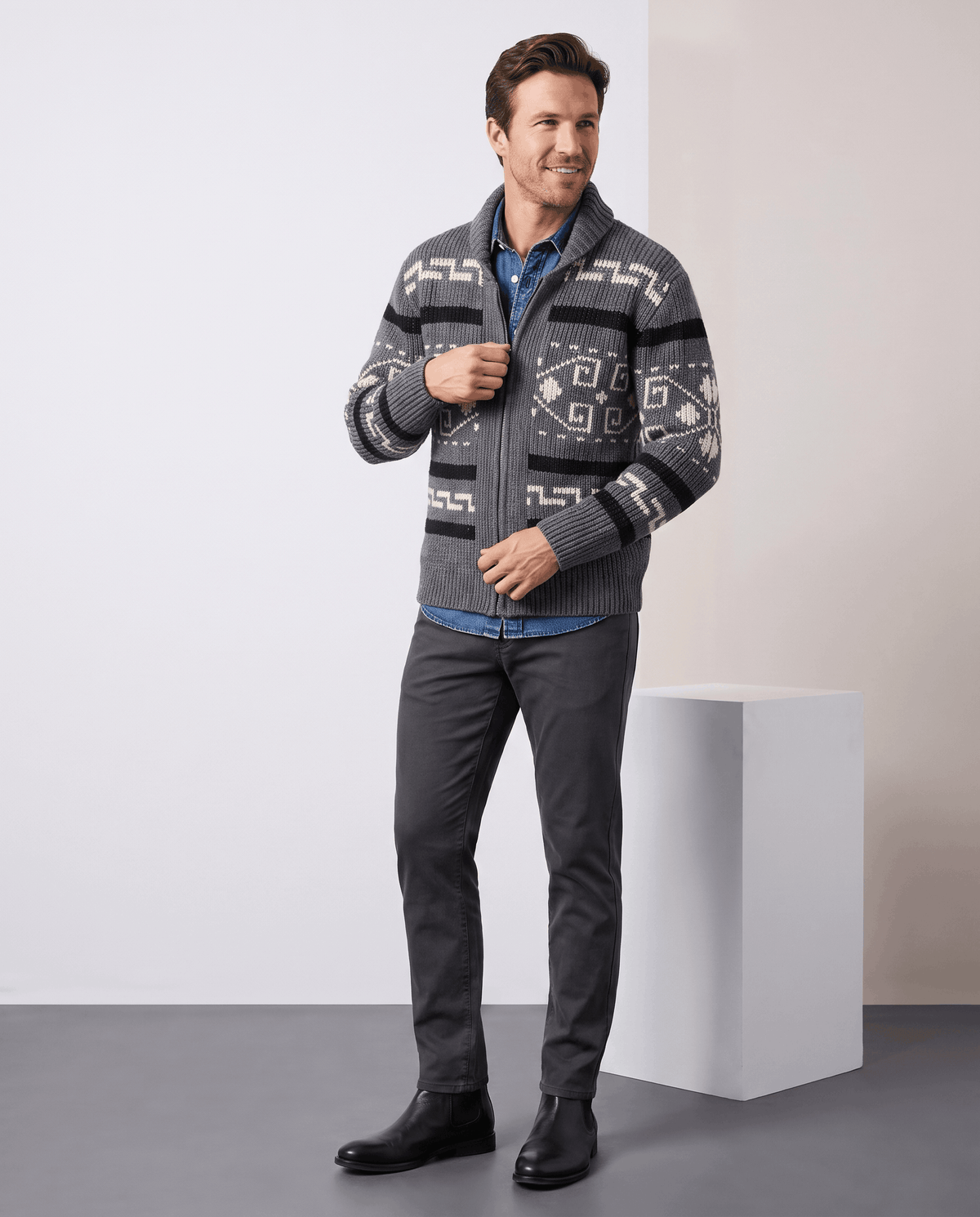 Full-length look with gray jacquard cardigan, dark trousers and black shoes