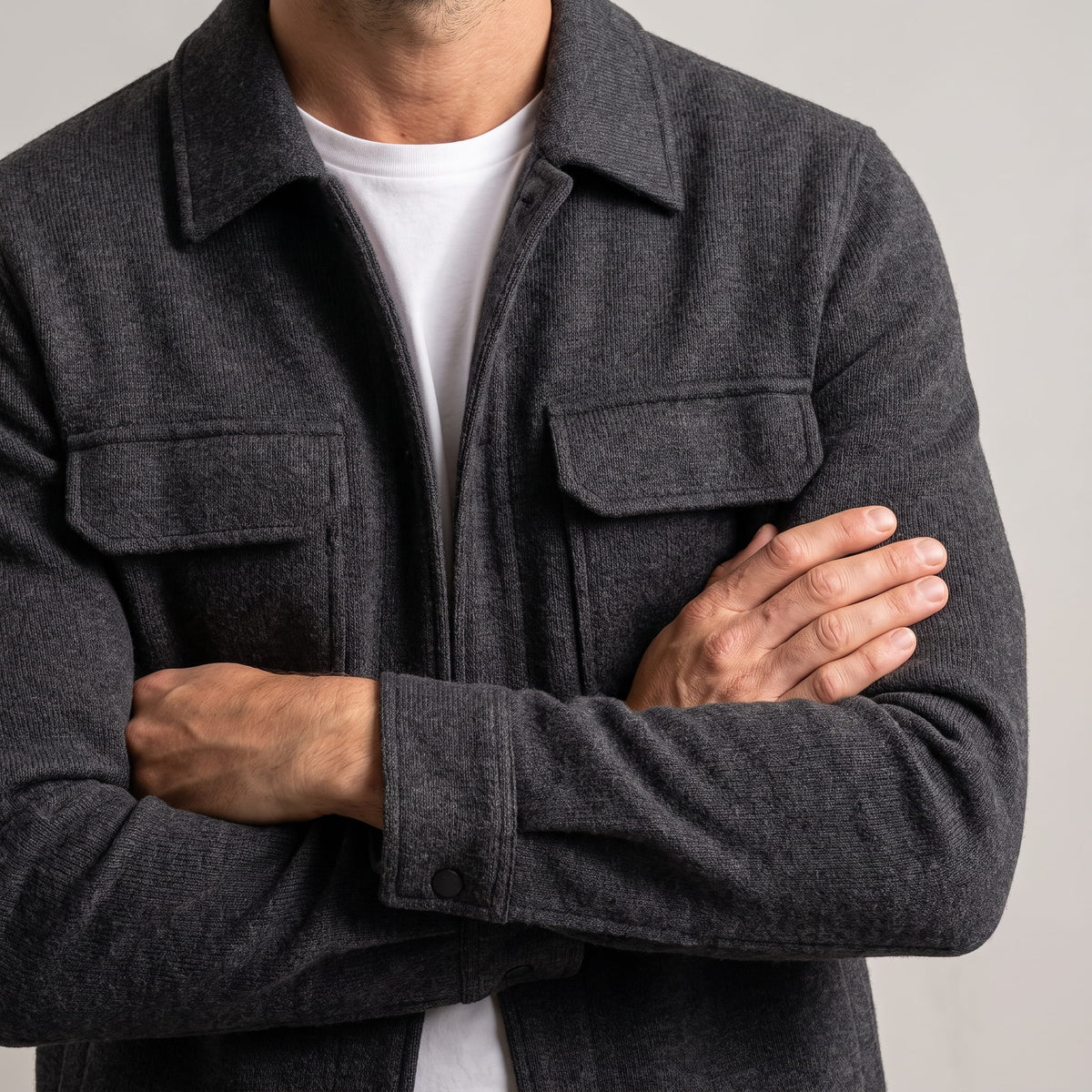 Close crop of the chest pockets and cuff button with arms folded