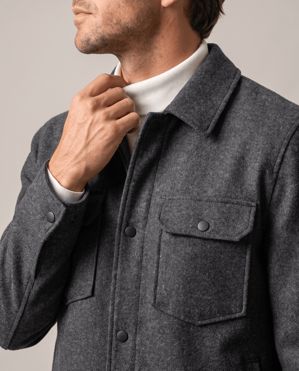 Hand adjusting the turn-down collar, showing a flap pocket button up close
