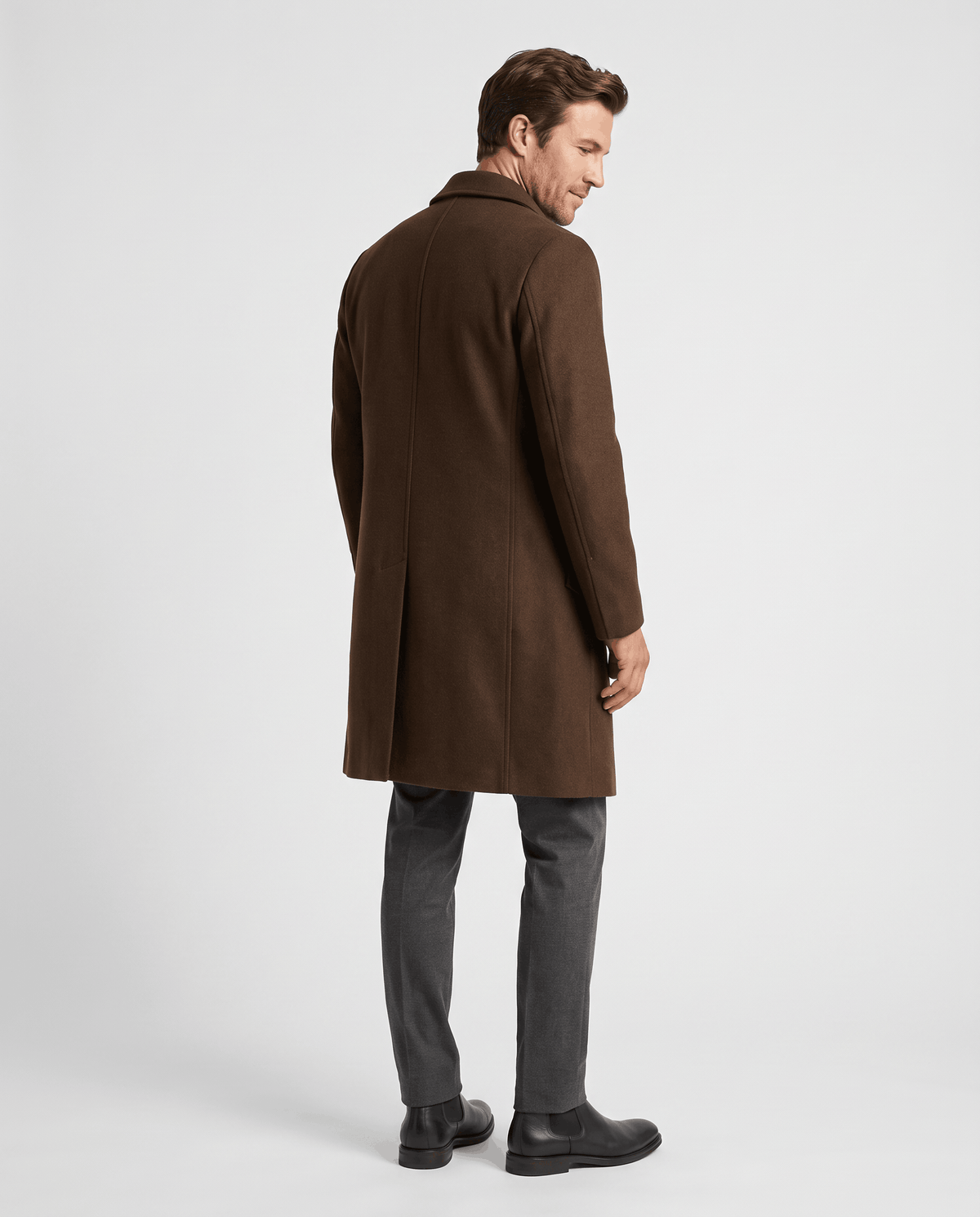 Back view of the brown overcoat worn with gray trousers and black boots