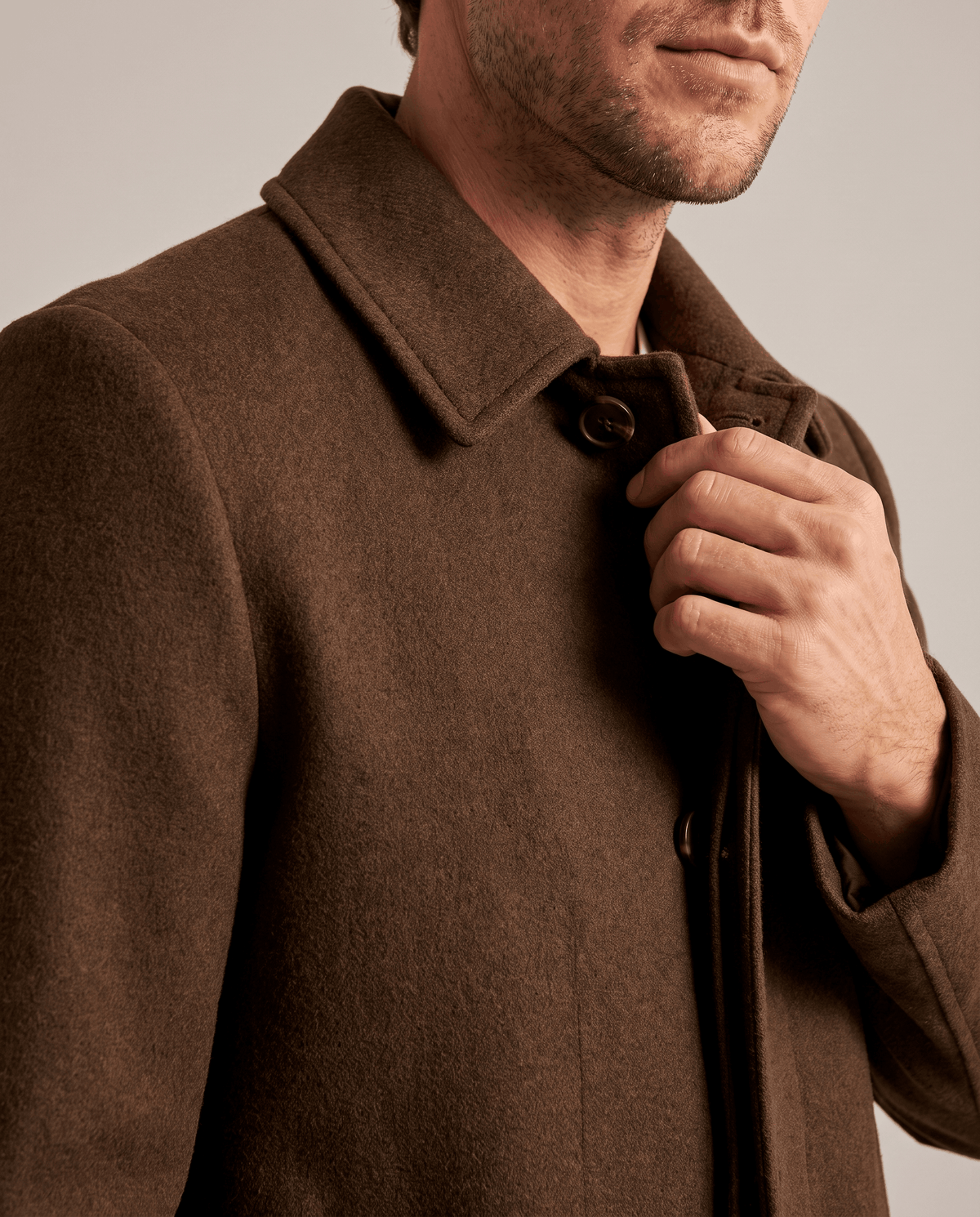 Close-up of the brown overcoat's collar and shoulder in a textured wool
