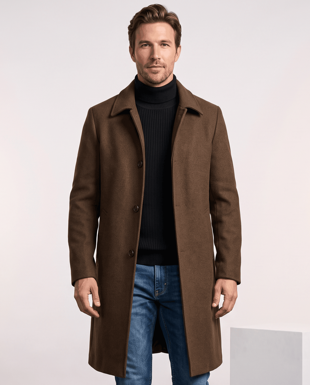 Men's single-breasted wool overcoat in brown, worn over a black turtleneck and jeans
