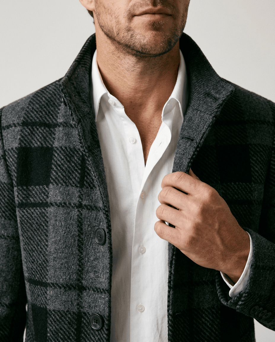 Close-up of the black and gray plaid pattern at the stand collar and shoulder