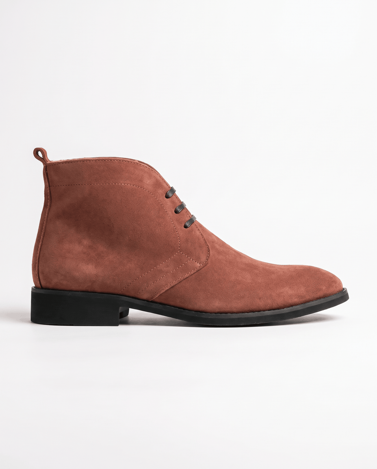 Side view of a brown suede chukka boot on a white background.