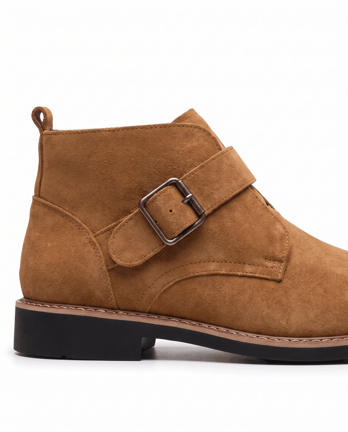 Tan suede boot side profile showing the heel pull tab, buckle strap and dark low sole
