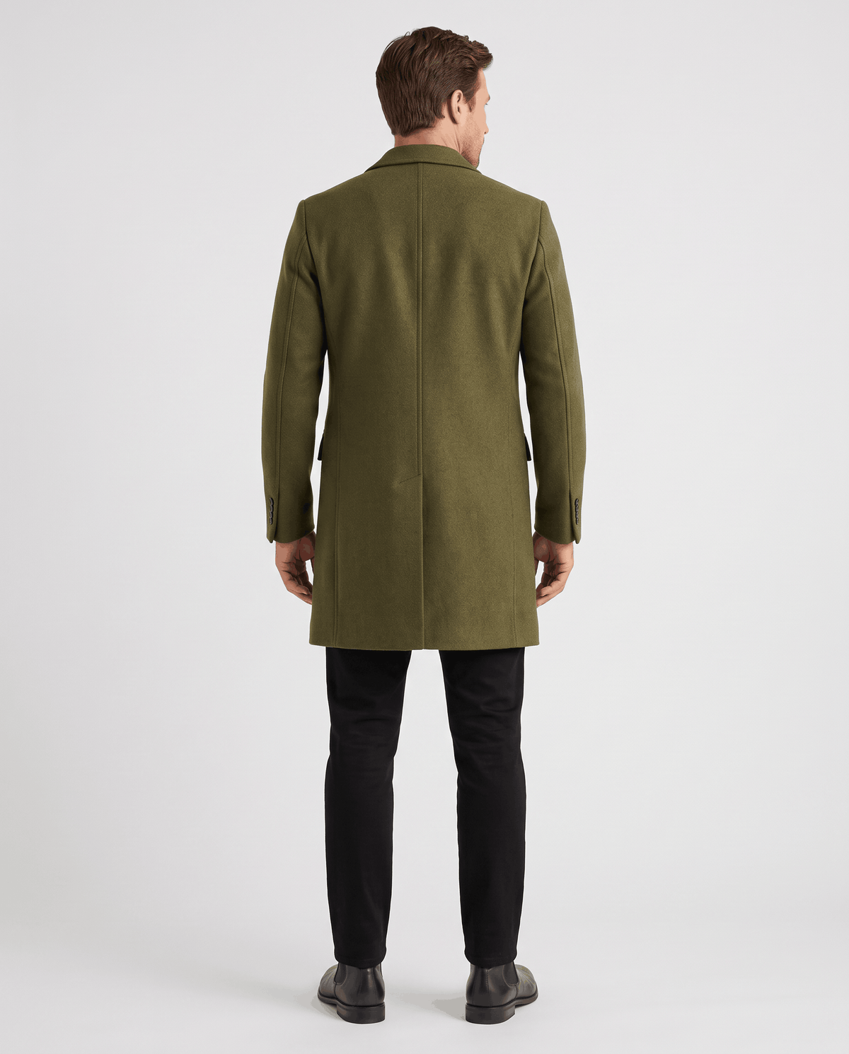 Back view of the army green overcoat worn with black trousers and shoes