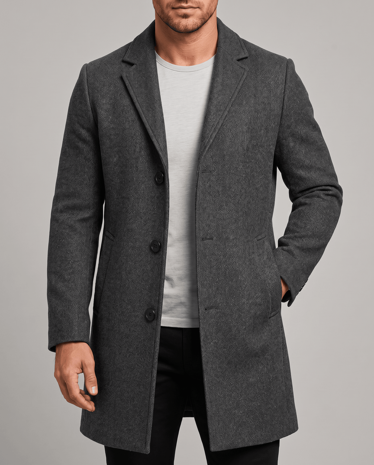 Dark gray overcoat in a front view with notch lapel, worn over a light gray tee