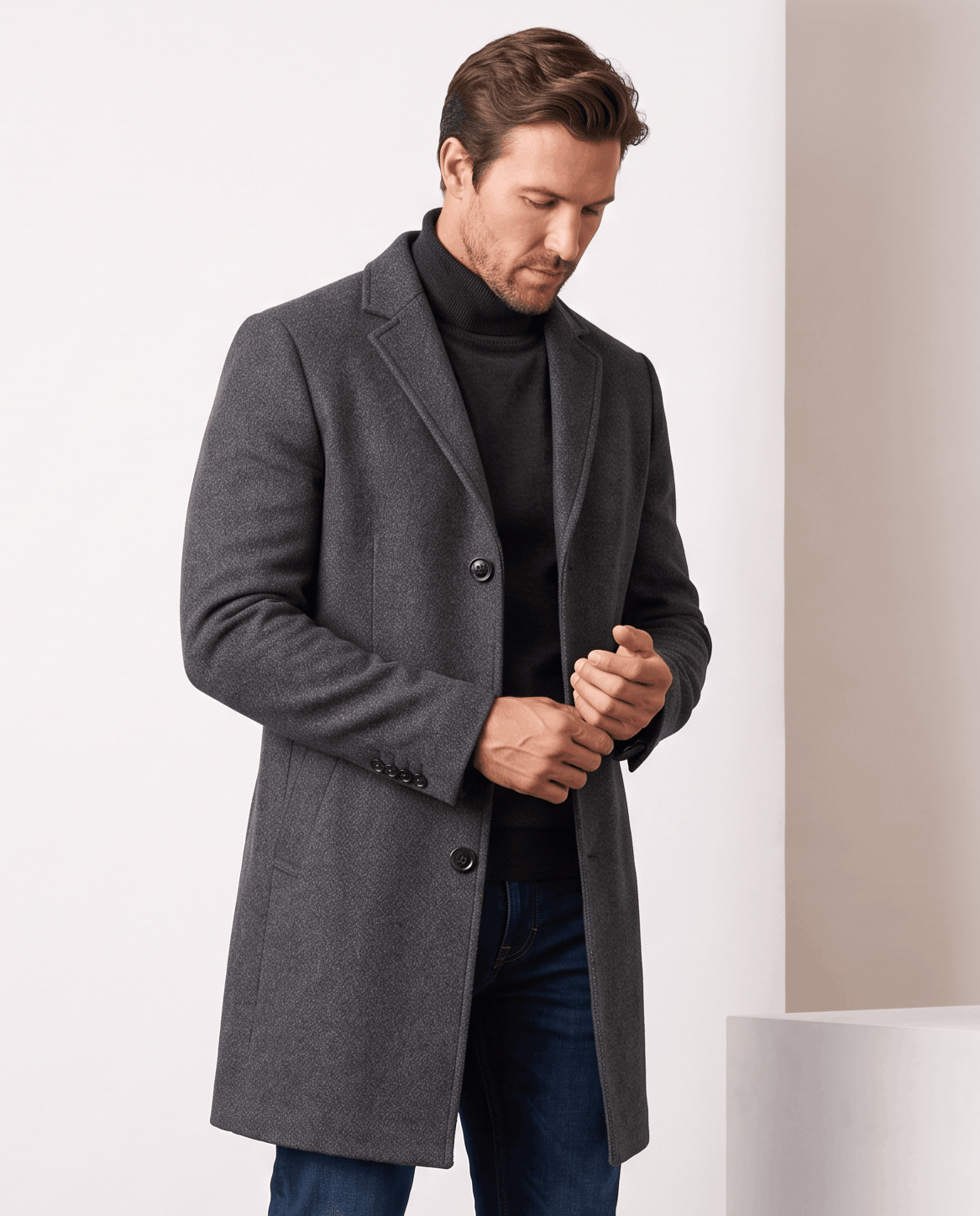 Dark gray overcoat with notch lapel and button front, worn over a black turtleneck