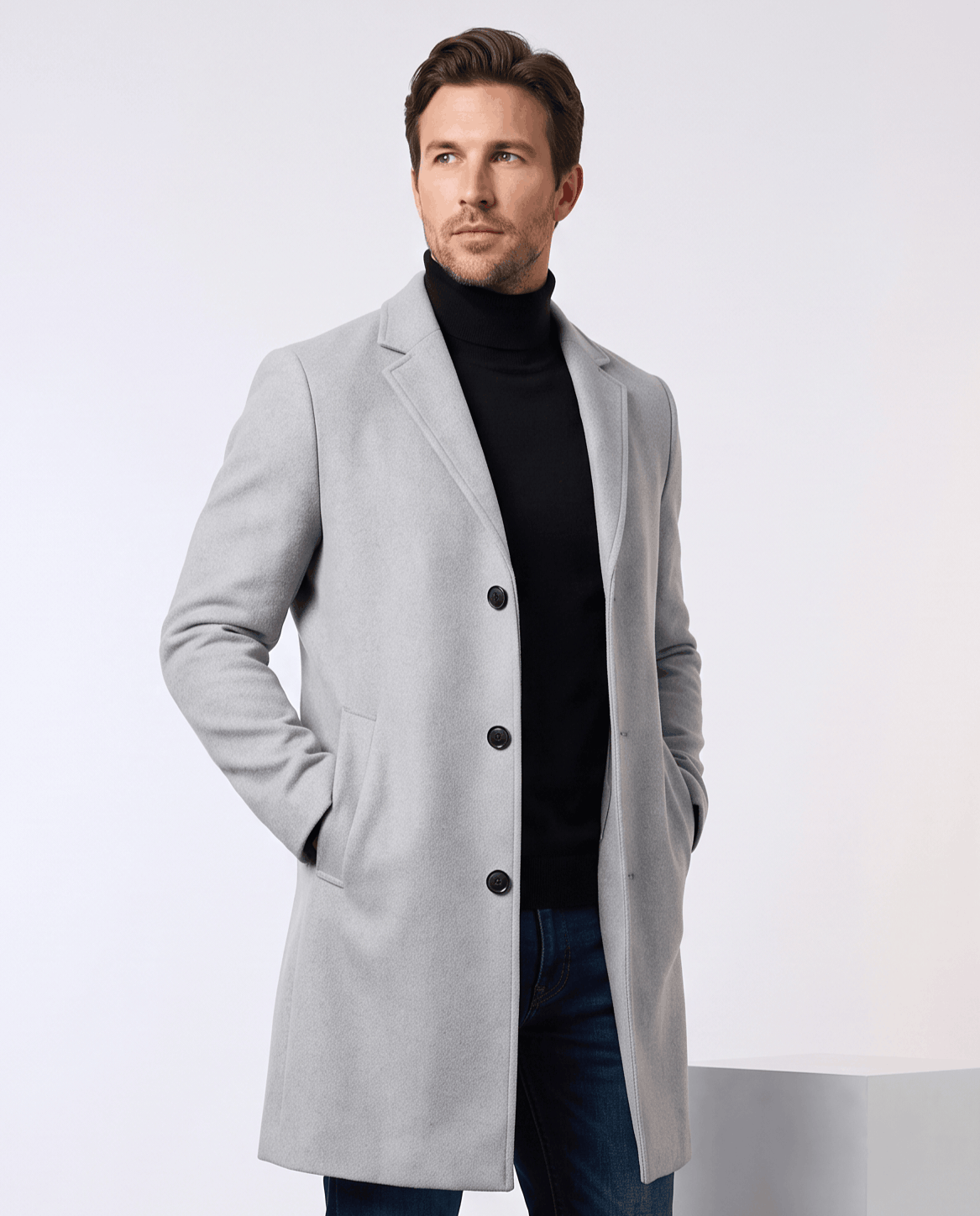 Light gray tailored overcoat worn over a black turtleneck, with a notch lapel