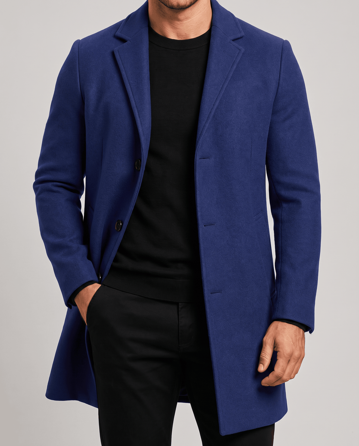 Blue overcoat front detail with notch lapel and button front, worn over a black top