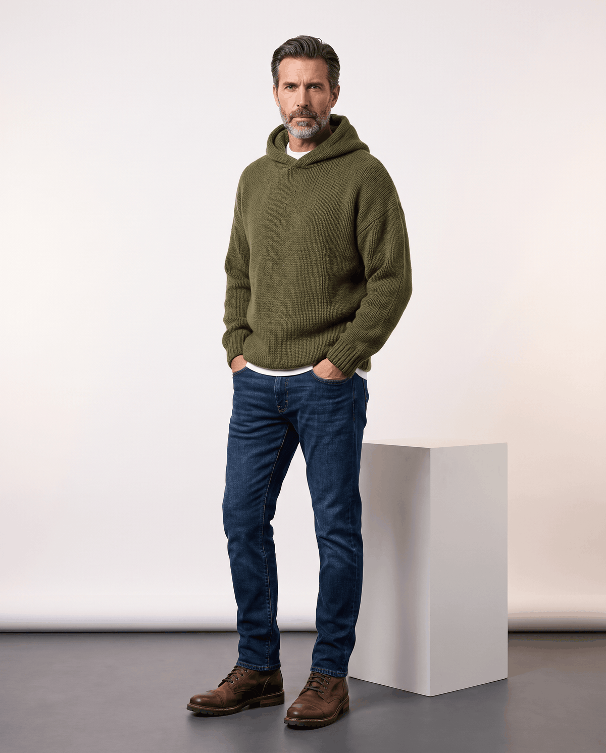 Full-length look: green knit sweater with a hood, blue jeans and brown boots