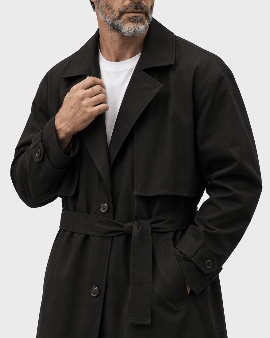 Close-up of the black coat's wide collar, tied belt and button placket worn over a white tee