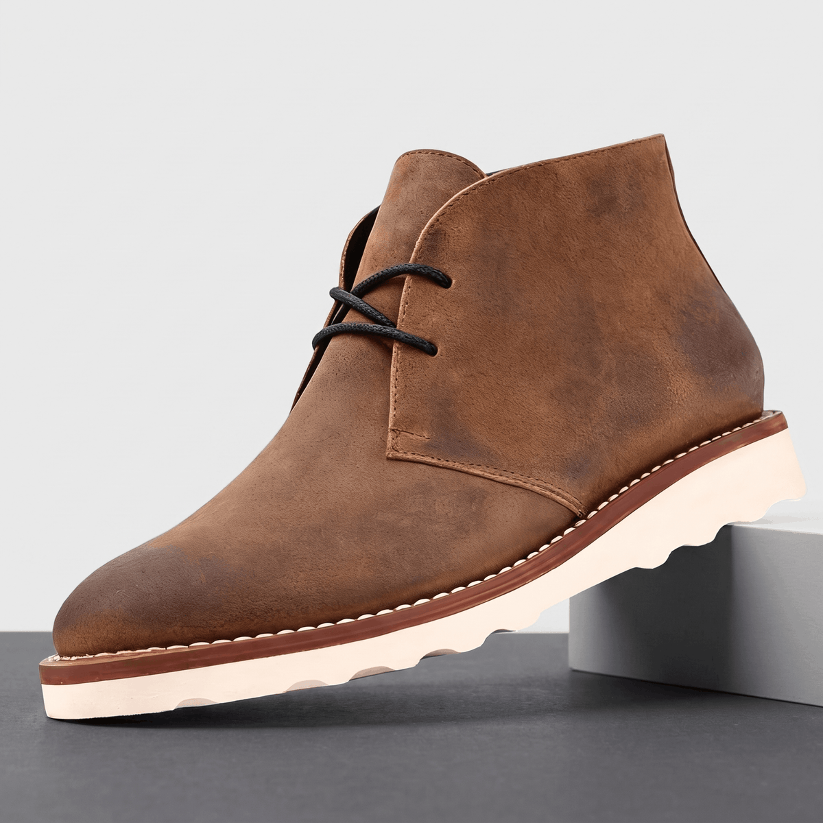 Light brown matte chukka boot with two-eyelet lacing, displayed on a white pedestal.