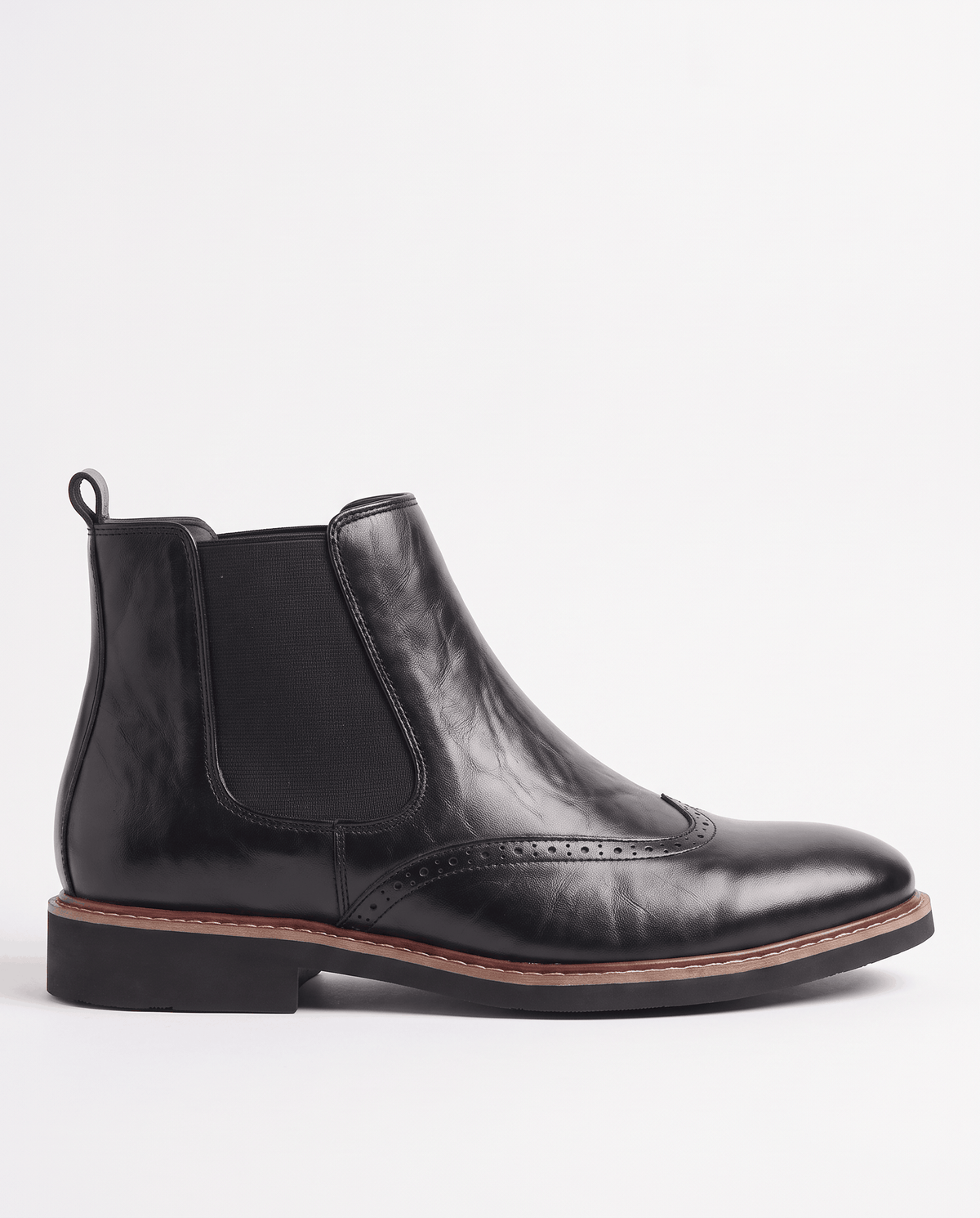 Black boot in side profile showing the elastic panel, heel pull tab and stitched sole edge