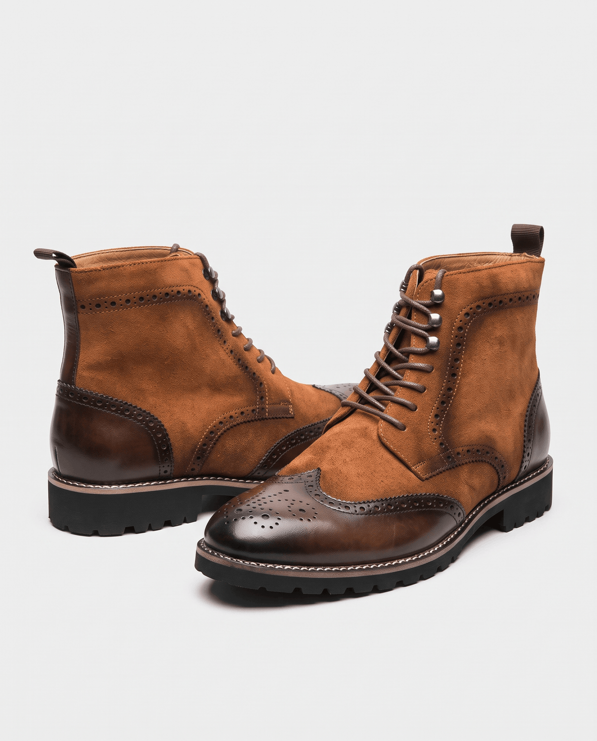 Cognac suede lace-up boots with polished brown wingtip toes side by side