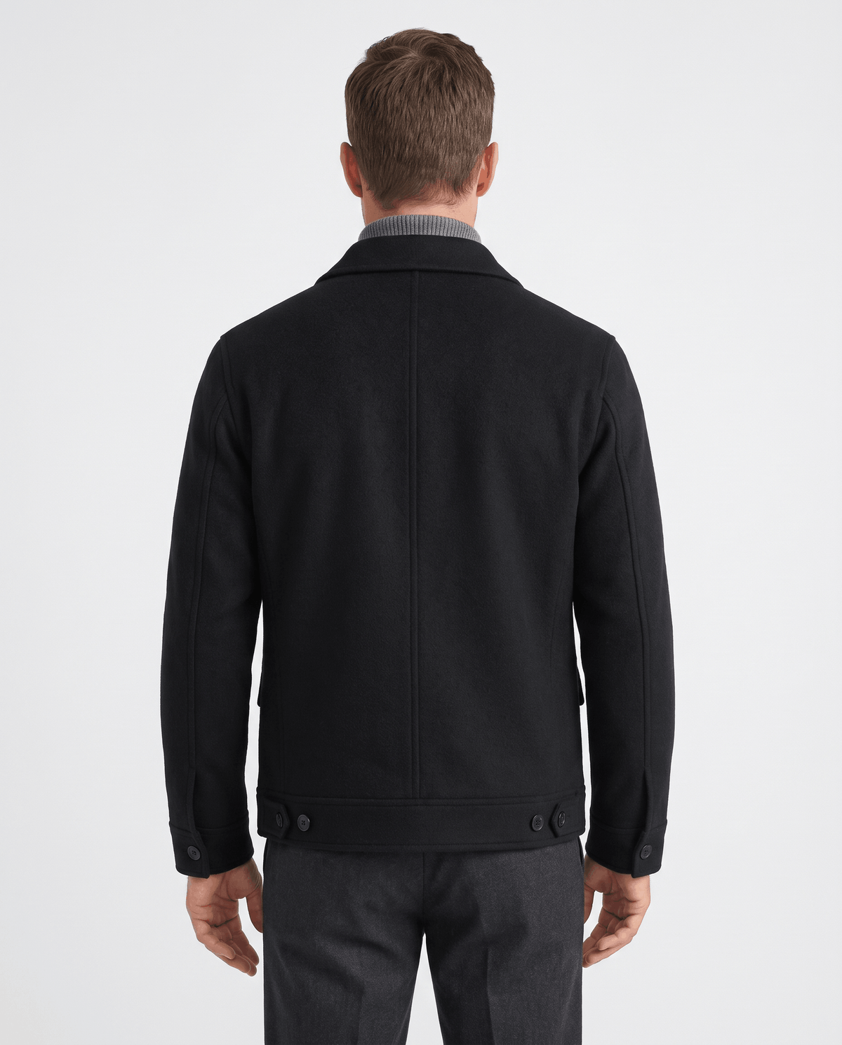 Back view of a black jacket showing the center seam and buttoned hem tabs