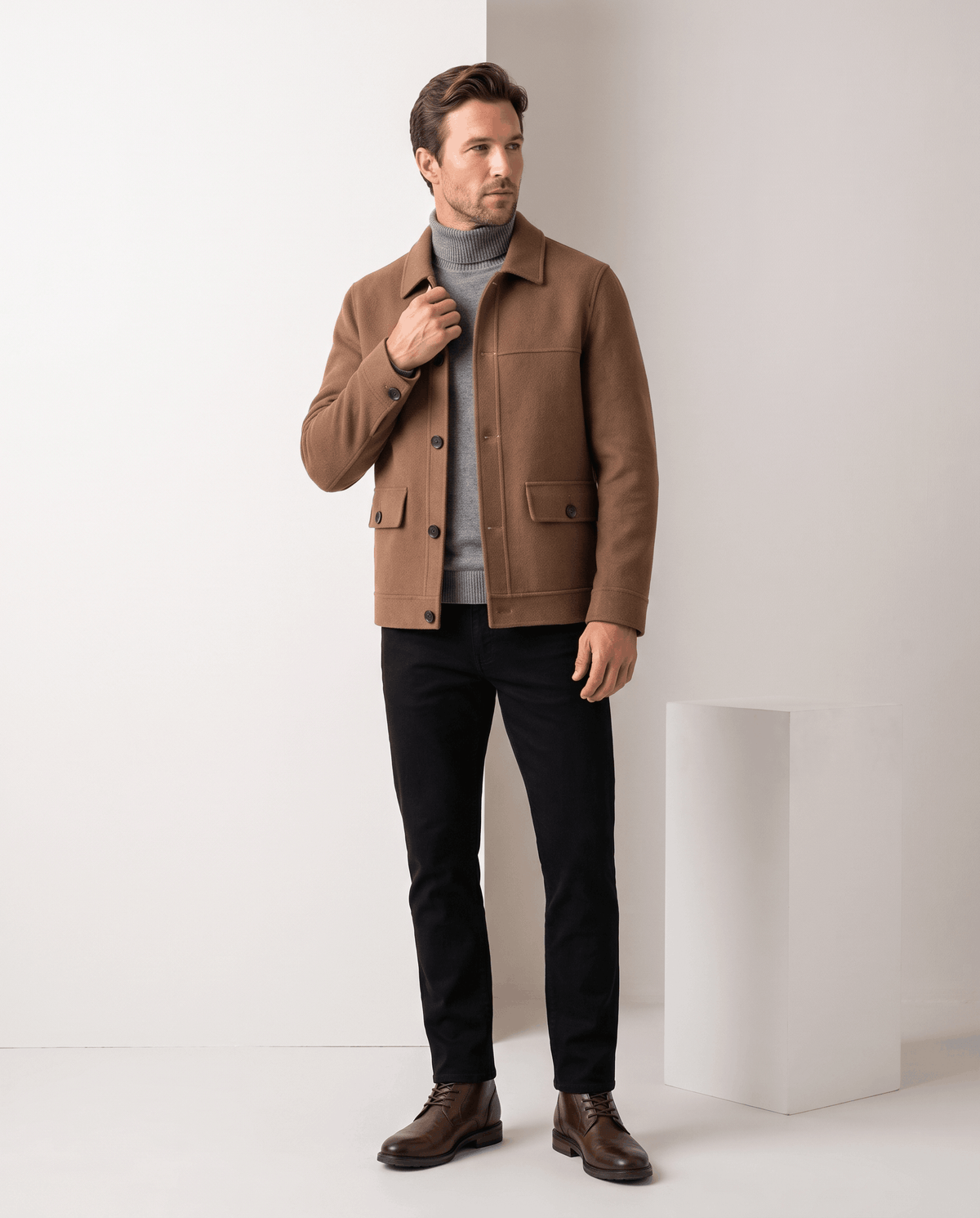 Full-length shot of a camel jacket styled with black jeans and brown boots